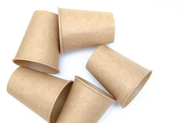 Brown paper cup for coffee, tea, a drink from environmental materials on a white background. A bunch of glasses. Glasses lie on their side in a circle in the form of a ring. Front and top view. Macro