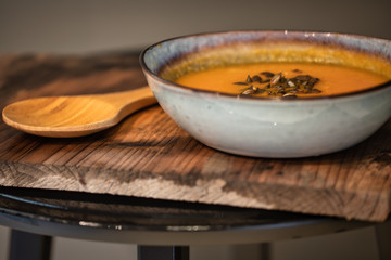 pumpkin carrot soup in a bowl on a wooden table, home made soup. healthy food close-up