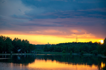 Naklejka premium Bright orange sunset over the pond