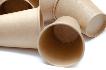 Brown paper cup for coffee, tea, a drink from environmental materials on a white background. A bunch of glasses. Glasses lie on their side in a circle in the form of a ring. Front and top view. Macro