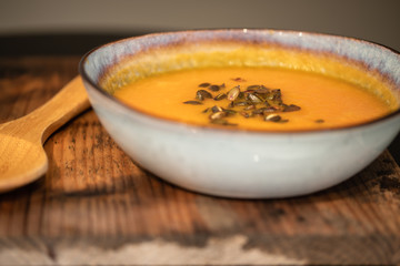pumpkin carrot soup in a bowl on a wooden table, home made soup. healthy food close-up