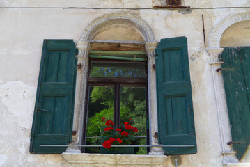 Fototapeta na wymiar Italy,the windows of the ancient houses of the charming village of Polcenigo