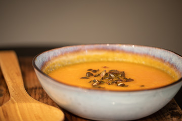 pumpkin carrot soup in a bowl on a wooden table, home made soup. healthy food close-up