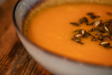 pumpkin carrot soup in a bowl on a wooden table, home made soup. healthy food close-up