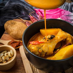 Massaman Curry With Chicken and Thai herbs with wood background texture