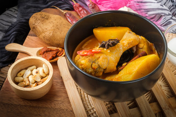 Massaman Curry With Chicken and Thai herbs with wood background texture