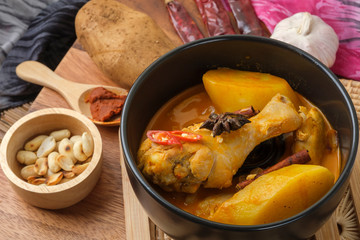 Massaman Curry With Chicken and Thai herbs with wood background texture