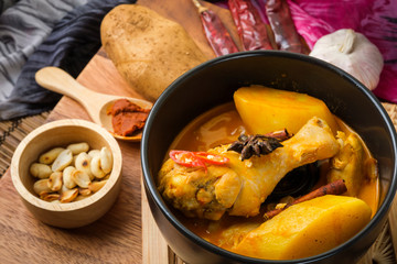 Massaman Curry With Chicken and Thai herbs with wood background texture