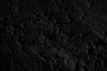 Black grunge background. Rough stone surface with cracks. Black rock texture. Mountains texture. Close-up.