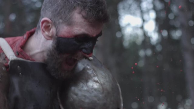 Scandinavic tattoo viking with scars screaming in wild forest