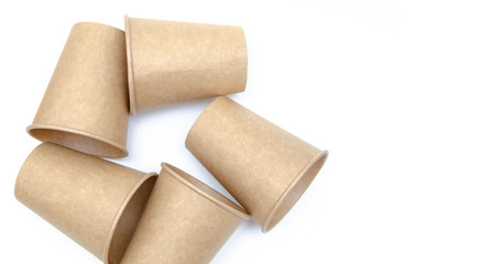 Brown paper cup for coffee, tea, a drink from environmental materials on a white background. A bunch of glasses. Glasses lie on their side in a circle in the form of a ring. Front and top view. Macro