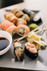 Freshly cooked sushi chef, delicious big rolls with avocado, cheese, salmon, sesame seeds