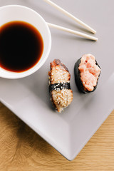 One beautiful gukan lying on a grey plate sprinkled with sesame seeds