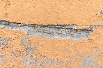 orange rough stucco on the wall with chips and cracks