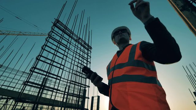 Male worker checks his phone after working with reinforcement.