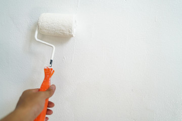 Hand paint white color roller on house wall maintenance