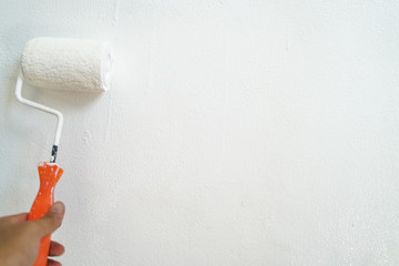 Hand paint white color roller on house wall maintenance