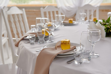Table setting with blank guest card, plates with napkins and cutlery, copy space. Place setting at wedding reception. Round table served for banquet in restaurant