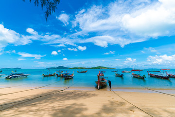 Travel longtale wooden boat on the white beach turquoise water at Phuket, Thailand.