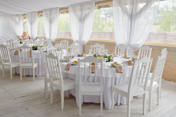 Table setting with blank guest card, plates with napkins and cutlery, copy space. Place setting at wedding reception. Round table served for banquet in restaurant
