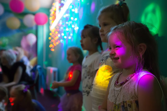 Celebrating the birthday of children.Children at a party in colored rays