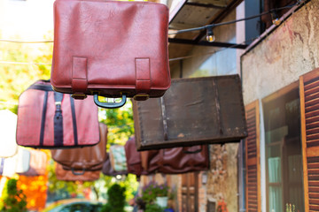 Old bags and suitcases are hanging in the sky. Exterior design of a thematic institution. Bag shop.