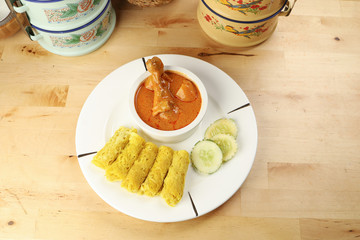 Traditional Malay snack food Roti Jala served with curry chicken with potato on white ceramic plate and bowl