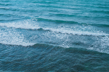 Naklejka na ściany i meble Texture of the sea or ocean with white lamb waves rolling to the shore.