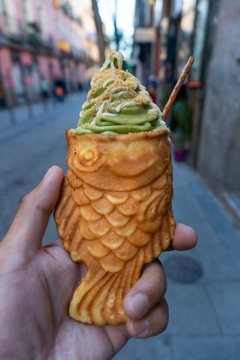 Taiyaki Green Tea Ice Cream handheld convenient snack treat on the streets of Madrid Spain. A fish shaped battered snack commonly found in Japan normally filled with a custard or bean paste.