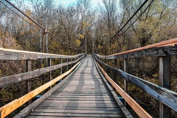 Obraz premium Most wiszący w lesie jesienią