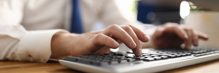 Male hands working with computer keyboard at office workplace