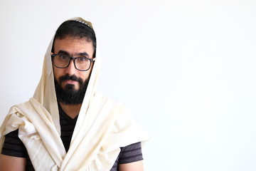 Bearded Jewish with a  Tallit (talis) . The man is standing in front of a white background and he...