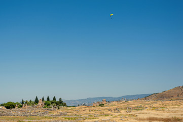 Paragliders flying above remains of anciet city of Hierapolis in Turkey.