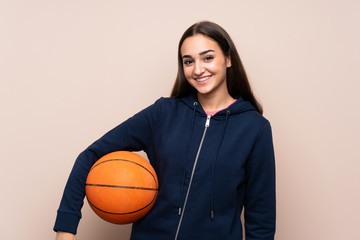 Young woman over isolated background with ball of basketball