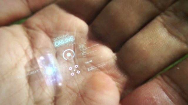 Futuristic computer in hand with a holographic interface.
