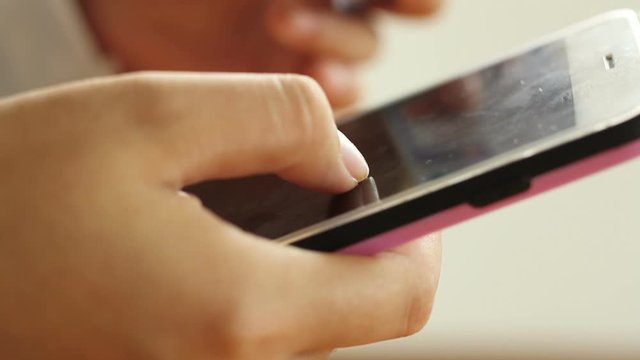 Hand of teenager woman typing a mobile phone to chat with friend or serching for a product through online shop at home.