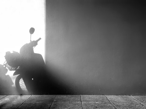 The light and shadow of the motorcycle on the concrete wall.