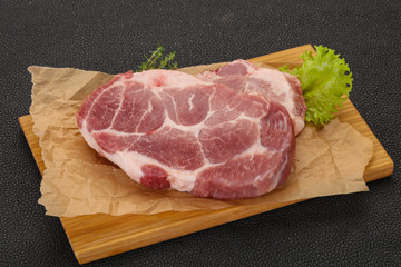 Raw pork steak over wooden board