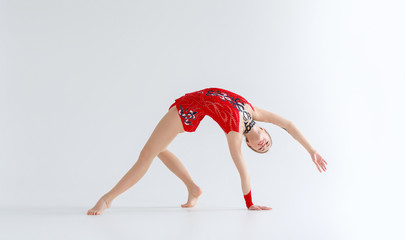 Rhythmic gymnastics practice. Flexible girl doing backbend exercise, isolated on white