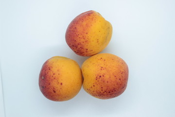 Ripe beautiful apricots are located on a white background