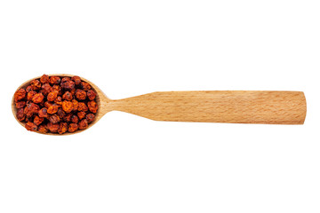 Dried Sorbus in a wooden spoon on a white background. Phytotherapy and disease prevention. Herbal collection for medicinal tinctures. Herbal tea in folk medicine. The view from the top