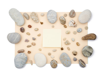 Fototapeta na wymiar Sticky notes in the middle of mix of rounded multicolor textured stones on beige paper background . Isolated flat lay with copy space