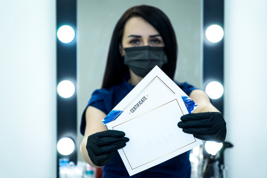 Beauty salon. A young woman in a protective mask. Gift certificate of a beauty salon.