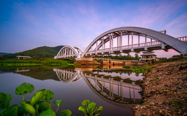 Fototapeta premium White Bridge or Saphan Tha Chomphu with reflection in twilight at Lamphun, Thailand.