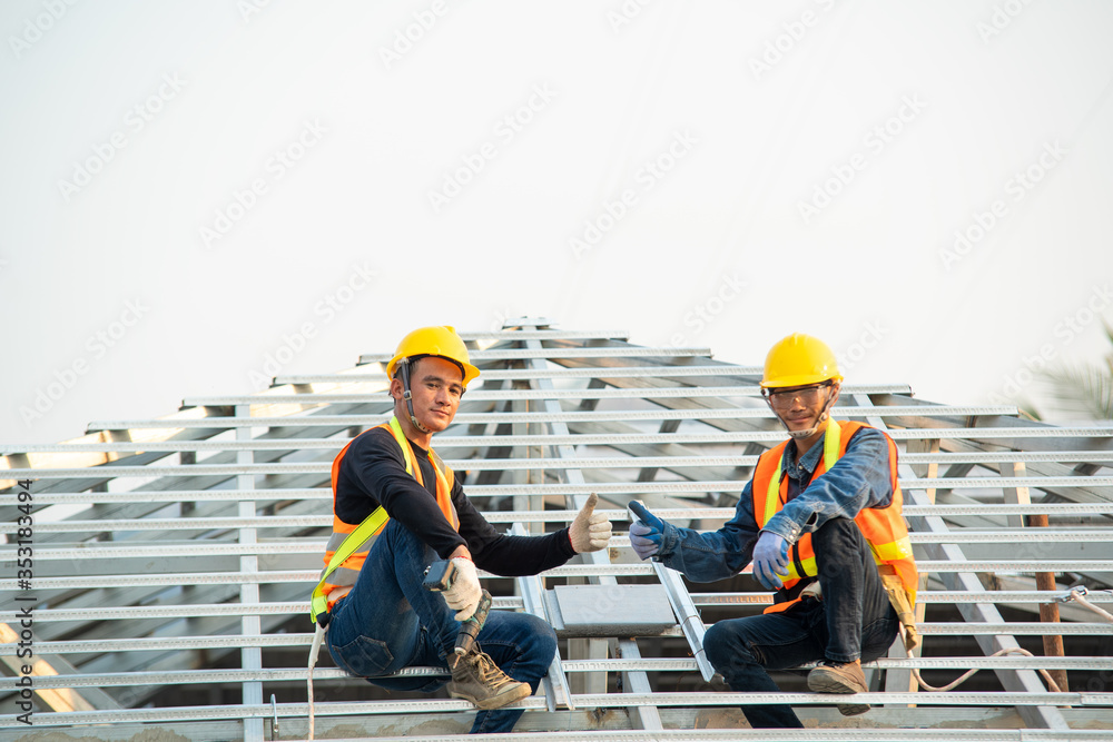 Poster Builder Working On Roof Of New house,Roofer builder working on roof structure of building on construction site.