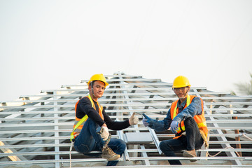 Builder Working On Roof Of New house,Roofer builder working on roof structure of building on...