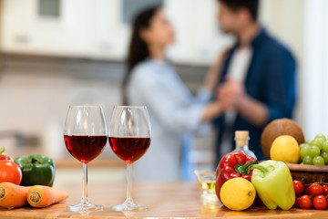 Lovely couple drinking wine in kitchen at their home