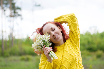 close up red haired dreamy girl with closed eyes posing with bouquet of white flowers in yellow...
