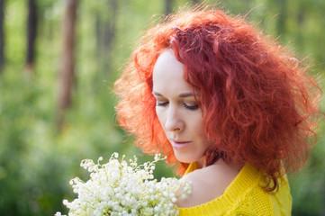 red haired romantic girl with bouquet of white flowers with naked shoulder in yellow sweater