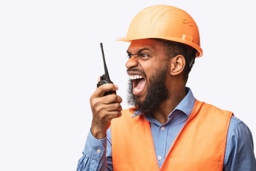 Angry Construction Foreman Worker Shouting In Two-Way Radio, Studio Shot - obrazy, fototapety, plakaty